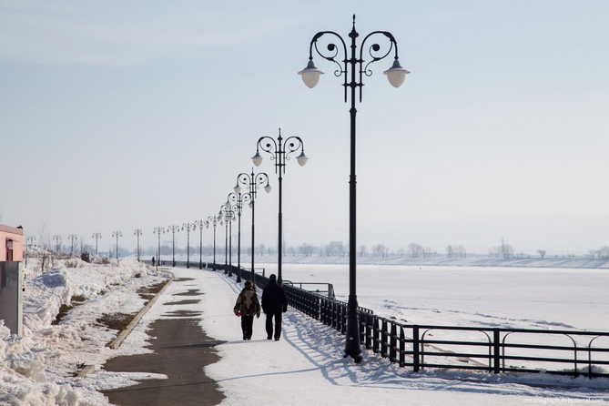 два человека идуи по набережной зимой