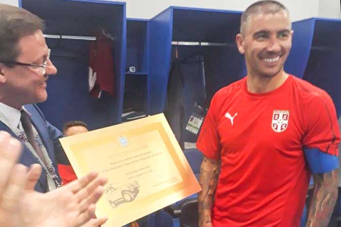 врио губернатора вручает сербскому футболисту сертификат на Lada 4х4
