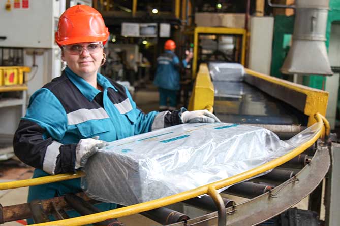 сотрудник Сибура держит брикет изопренового каучука на основе изопентана