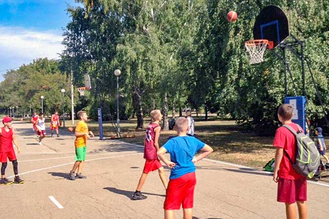 ученики играют в баскетбол в парке