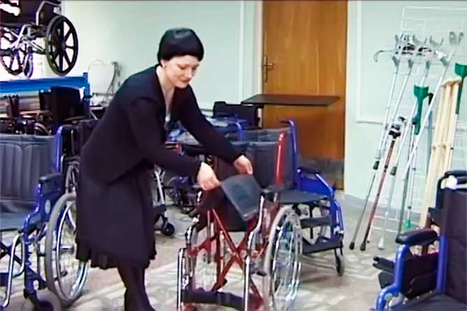 женщина складывает коляску