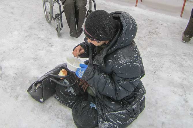 мужчина ест прям на снегу