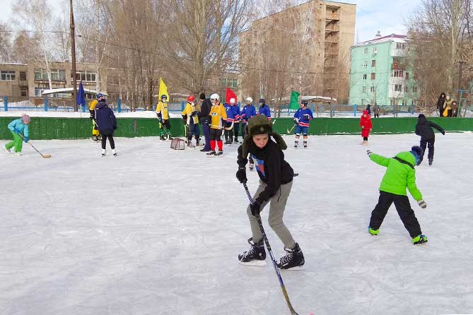 дети играют в хоккей во дворе дома 158 по улице Мира